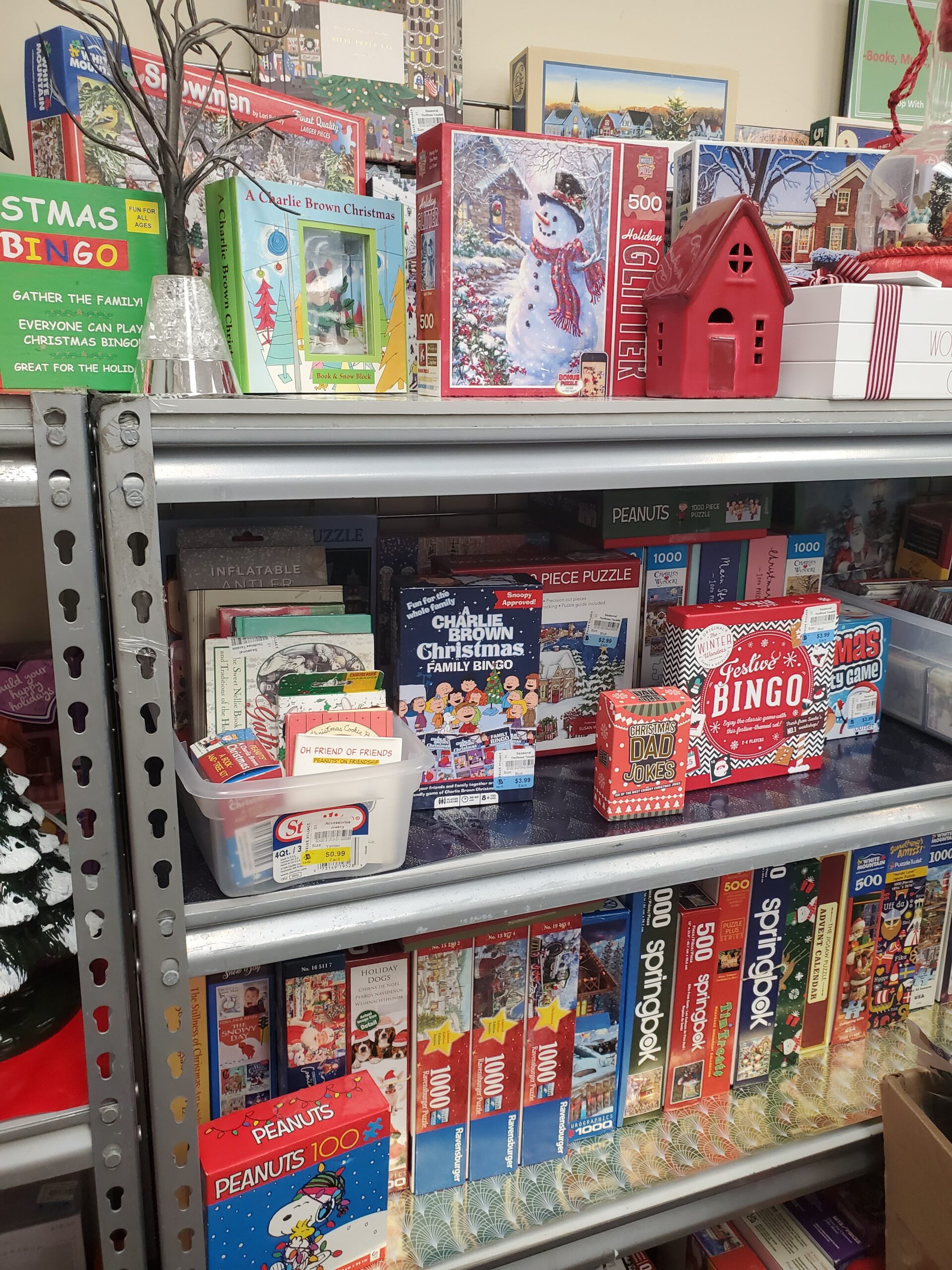 Holiday themed games and puzzles on a shelf for sale at a thrift store.