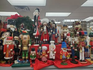 Colorful nutcrackers arranged for sale on a thrift store shelf.